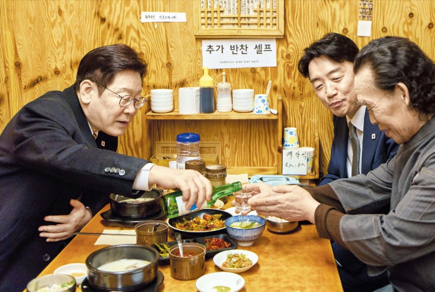 청와대대통령이 따라주는 술  이재명 대통령이 9일 강훈식(가운데) 비서실장과 함께 서울 종로구 통인시장의 한 식당을 찾아 식사를 하며 식당 상인(오른쪽)에게 소주를 따라주고 있다.