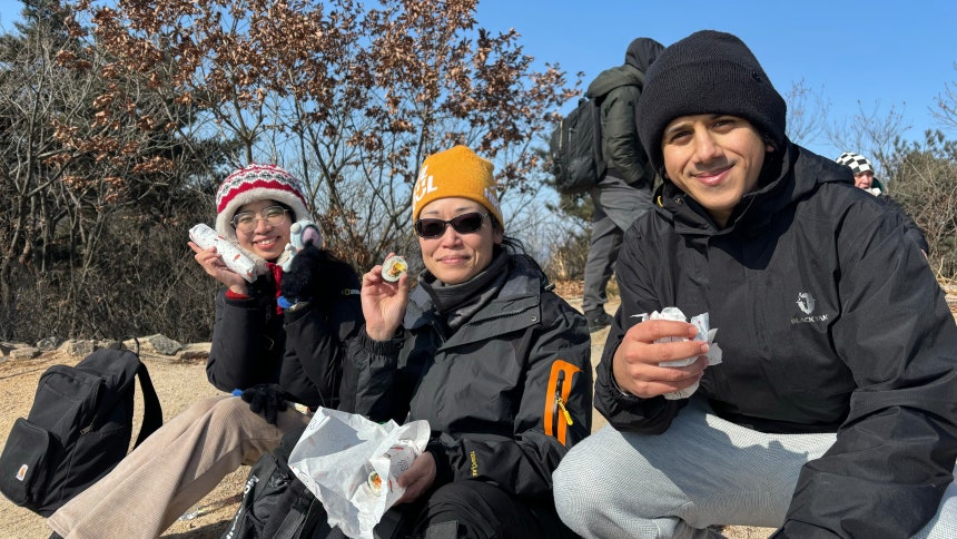 8일 오후 1시쯤 북한산 영봉에서 외국인 관광객들이 김밥과 K팝 아이돌 인형을 들고 포즈를 취하고 있다. 이날 최저기온 영하 15도의 한파 속에 네팔·슬로바키아·필리핀·캐나다·미얀마·호주·인도네시아·파키스탄 등에서