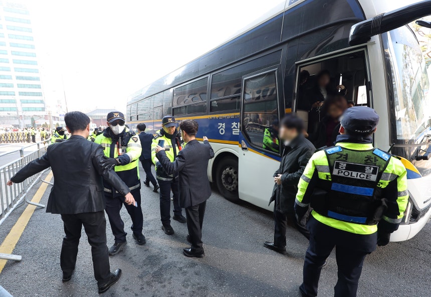그룹 방탄소년단(BTS)이 정규 5집 '아리랑'(ARIRANG) 발매를 기념해 무료 공연을 여는 21일 서울 광화문 광장 인근 결혼식장을 방문한 하객들이 경찰버스에서 내려 검문검색