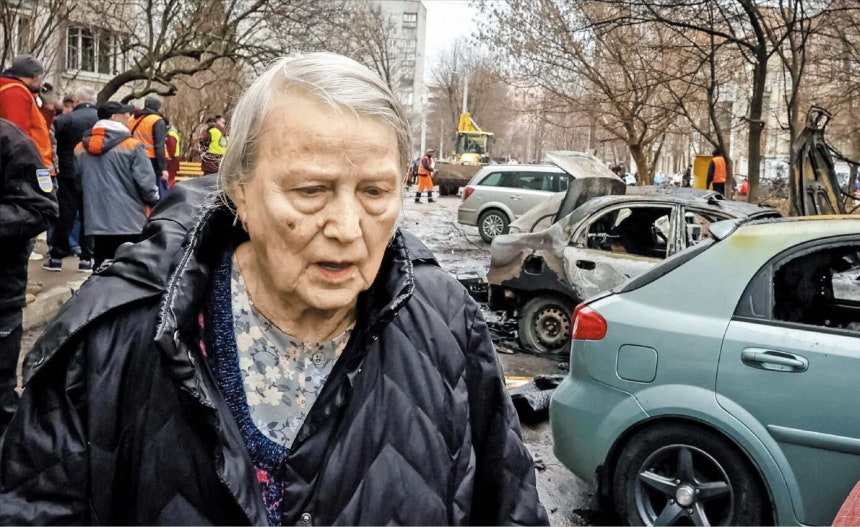 25일 우크라이나 하르키우에서 한 주민이 이틀 전 러시아의 드론 공습으로 파손된 차량들 사이를 지나가고 있다./로이터