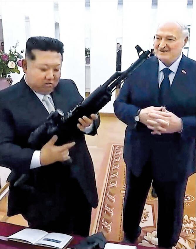 26일 알렉산드르 루카셴코(오른쪽) 벨라루스 대통령과 만난 북한 김정은이 선물받은 소총을 살펴보는 모습.미국과 이란의 전쟁에 국제사회의 관심이 쏠린 사이 우크라이나를 겨냥한 러시아의 공세가 거세지고,러시아·북한·