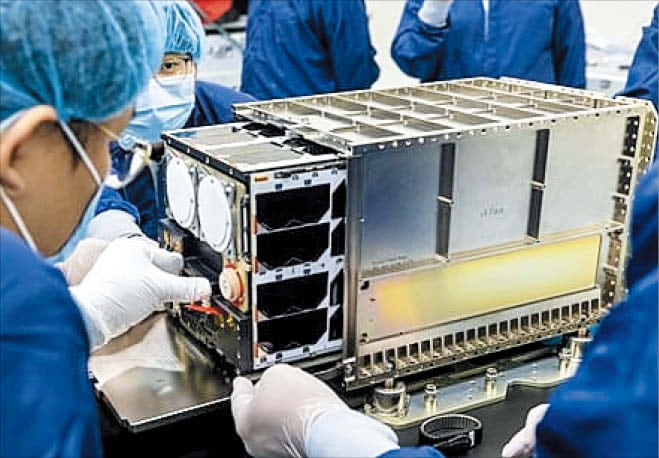 NASA우주항공청과 한국천문연구원 관계자들이 ‘아르테미스 2호’ 탑재를 앞두고 초소형 위성 ‘K-라드큐브’를 살펴보고 있다.