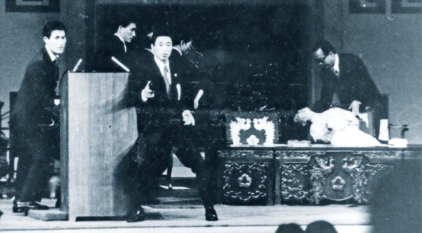 육영수 여사 피격 순간 1974년 8월 15일 서울 국립극장에서 문세광이 총격을 가한 직후의 모습.대통령 경호실 수행계장 박상범이 권총을 든 채 연단을 호위하고 있다.오른쪽에는 총탄을 맞고 쓰러진 육영수 여사의