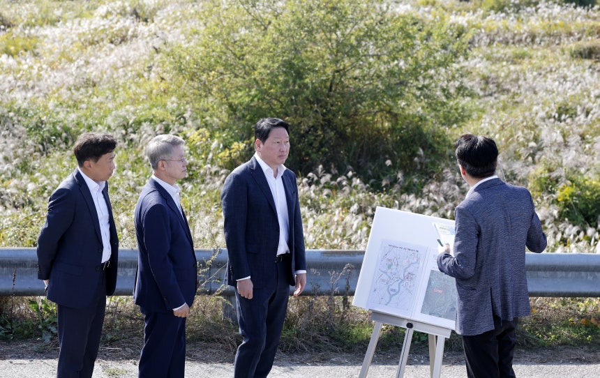 최태원(가운데) SK그룹 회장과 민형배(왼쪽) 전남광주통합특별시장이 9일 서남권 반도체 클러스터 예정지인 광주 군공항 탄약고 인근 부지에서 시 관계자로부터 산업단지·인프라 조성 계획에 대한 설명을 듣고 있다.서남권