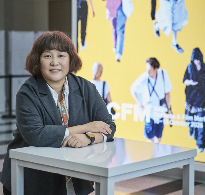 ACFMの展示会場を背景に座るキム・ヨンドク委員長