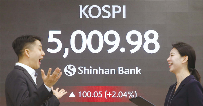  코스피가 사상 처음 장중 5000선을 넘어선 가운데,지난 1월 22일 오전 서울 중구 신한은행 본점 딜링룸에서 직원들이 기뻐하고 있다.(신한은행 제공)