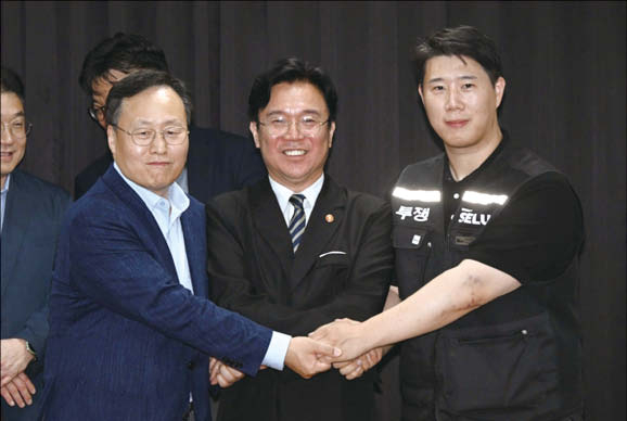  지난 5월 20일 여명구 삼성전자 DS(반도체 사업) 피플팀장과 최승호 삼성그룹 초기업노동조합 삼성전자지부 위원장이 잠정 합의안에 서명한 후 김영훈 고용노동부 장관과 기념촬영을 하고 있다.(공동취재)