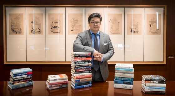 김병주 MBK파트너스 회장이 서울 광화문 사무실에서 좋아하는 책들을 놓고 포즈를 취하고 있다. 김 회장은 매년 새해나 명절 등에 직원들에게 추천 도서 목록을 만들어 돌릴 정도로 다독가다. 사진 MBK파트너스