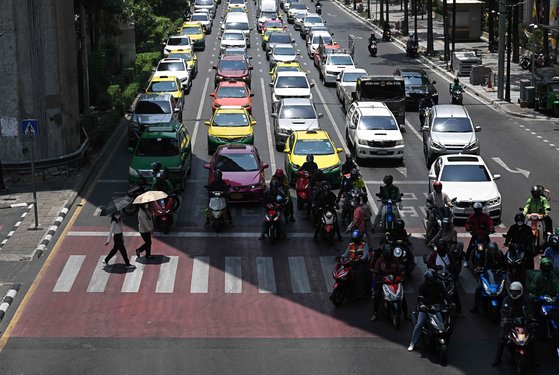 지난 1일 태국 방콕에서 오토바이 운전자들이 더위를 피해 그늘 아래서 신호를 기다리고 있다. AFP=연합뉴스