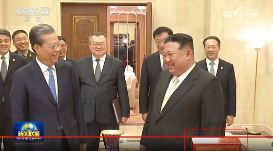 13일 평양 노동당 청사에서 김정은(앞줄 오른쪽) 북한 국무위원장이 자오러지(왼쪽) 중국 전인대 상무위원장에게 선물을 받고 미소짓고 있다. 오른쪽 아래에 중국의 국주로 불리는 마오타이 30년산 상자가 보인다.  CC