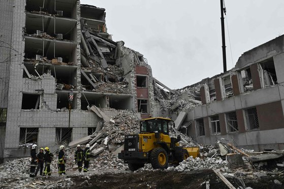 지난 17일(현지시간) 러시아의 공격으로 무너진 우크라이나 체르니기우의 건물 잔해를 구조대원들이 치우고 있다. AFP=연합뉴스
