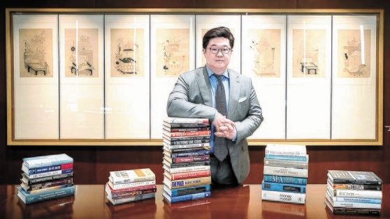 김병주 MBK파트너스 회장이 서울 광화문 사무실에서 좋아하는 책들을 놓고 포즈를 취하고 있다. 김 회장은 2024 포브스 선정 한국 50대 부자에서 2위를 차지했다. 사진 MBK파트너스
