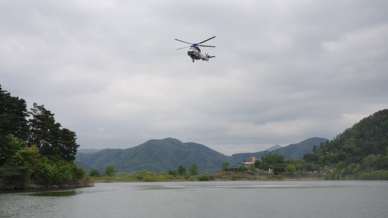 경찰 헬기가 지난 22일 전북 임실군 옥정호 상공에서 실종된 건설사 대표 A씨(64)를 찾고 있다. 사진 전북특별자치도소방본부