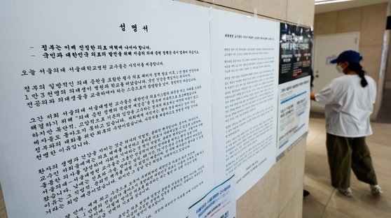 서울대병원 교수들의 일반 환자 외래 진료·수술 휴진을 하루 앞둔 29일 종로구 서울대병원에 정부 의대 증원 정책 중단을 촉구하는 비대위 성명서가 붙어있다. 뉴스1