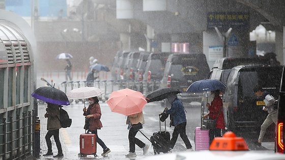 지난해 5월 4일 어린이날 연휴를 맞아 제주도를 방문한 관광객들이 우산을 쓴 채로 발걸음을 재촉하고 있다. 뉴시스