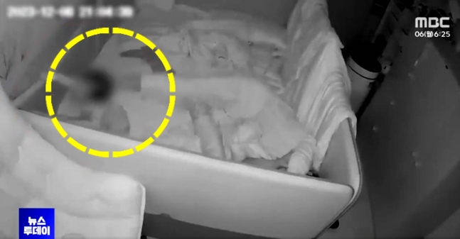 침대 가드를 잡고 일어서려는 11개월 아기를 육아도우미가 발을 이용해 쓰러뜨리고 있다. 사진 MBC 캡처 