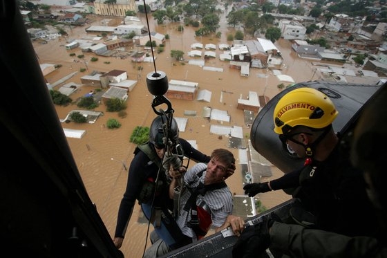 지난 4일(현지시간) 브라질 히우그란지두술주 카노아스에서 홍수가 발생한 후 한 남자가 군 소방관들에 의해 구조되고 있다. 로이터=연합뉴스