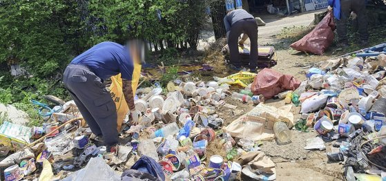 지난 2일 경남 함안군 대산면 한 주택 안밖에 쌓인 쓰레기를 함안지역자활센터 직원들이 치우고 있다. 이 집에서는 사흘간 2.5t 쓰레기가 나왔다. 사진 경남도