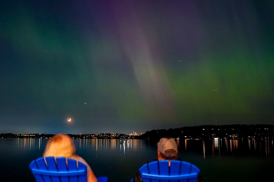 10일 밤 미국 워싱턴주 렌튼의 워싱턴 호수에서 오로라를 관측하는 모습. AP=연합뉴스