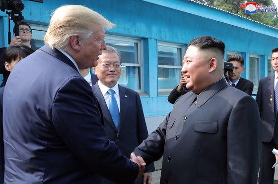 2019년 6월 도널드 트럼프 전 미국 대통령과 김정은 북한 국무위원장이 판문점에서 악수하는 모습을 문재인 전 대통령이 바라보는 모습. 연합뉴스.