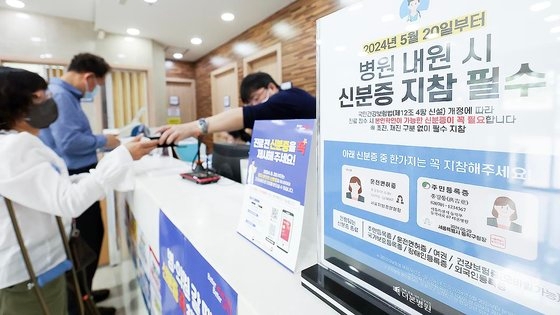 건강보험 본인확인 의무화 제도가 시행된 20일 오전 서울 동작구 한 병원에서 시민이 접수를 하며 모바일신분증을 보여주고 있다. 뉴스1