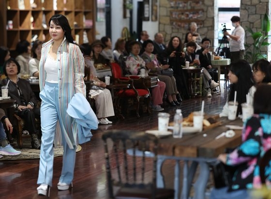 지난 4월 서울 강남의 한 베이커리카페에서 열린 ‘설영희 마리에블랑 부띠끄’ 패션쇼에서 한 시니어 모델이 워킹을 하고 있다. 연합뉴스
