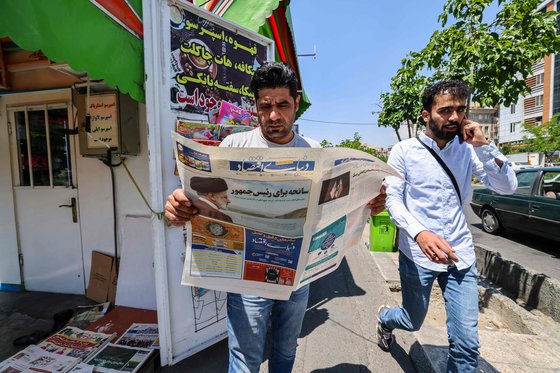 한 이란 남성이 20일 이란 수도 테헤란에서 에브라힘 라이시 이란 대통령이 헬기 추락 사고로 사망한 내용이 담긴 신문을 읽고 있다. AFP=연합뉴스