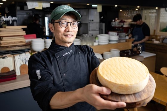 지난달 4일 서울 한남동의 치즈 전문 레스토랑 '치즈플로'에서 오너이자 치즈 장인인 조장현 셰프와 만났다. 그가 2개월 걸려 만든 톰(Tomme) 치즈를 들고 있다. 전민규 기자