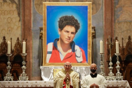 2020년 10월 이탈리아 아시시의 성 프란시스 대성당에서 아고스티노 발리니 추기경이 거행한 시복식 모습. 2006년 백혈병으로 사망한 소년 카를로 아쿠티스(당시 15세)의 사진이 걸려 있다. AP=연합뉴스