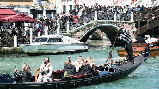 이탈리아 베네치아를 방문한 관광객들이 지난달 25일 운하에서 곤돌라를 타며 인증 사진을 찍고 있다. 베네치아 지역 주민 500여명은 이날 다리 위에서 입장료 부과 제도가 도시를 일종의 '베니랜드(베네치아+디즈니랜드)
