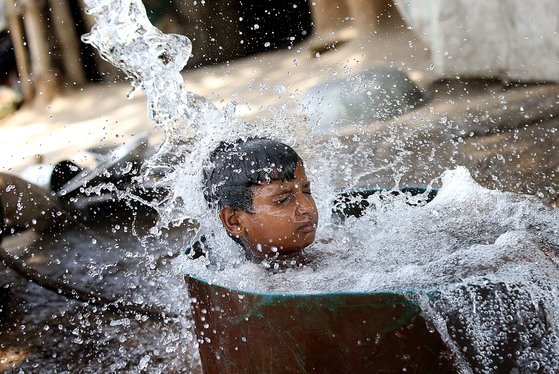 31일(현지시간) 인도 뉴델리에서 한 소년이 더위를 식히기 위해 목욕을 하고 있다. EPA=연합뉴스