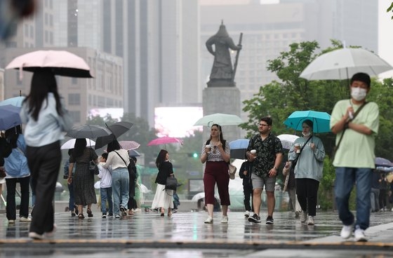 지난달 26일 비가 내리는 서울 광화문광장에서 시민들이 우산을 쓴 채 걸어가고 있다. 연합뉴스