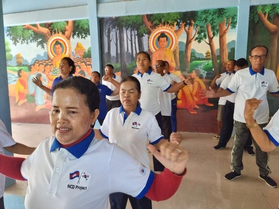 캄보디아 프놈펜 외곽의 주민들이 파고다(절)에서 건강댄스를 즐기고 있다. 코이카·한국건강관리협회·전북대가 공동으로 프로젝트를 진행하며 걷기·식습관 교정 등을 통해 주민들의 고혈압·당뇨병 같은 비감염성질환을 예방한다.