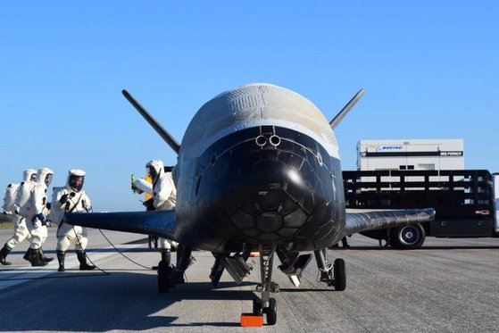 특수방호복을 입은 미 공군 인원들이 무인 우주왕복선 X-37B를 점검하고 있다. X-37B에 대한 모든 내용은 비밀이다. 미 공군