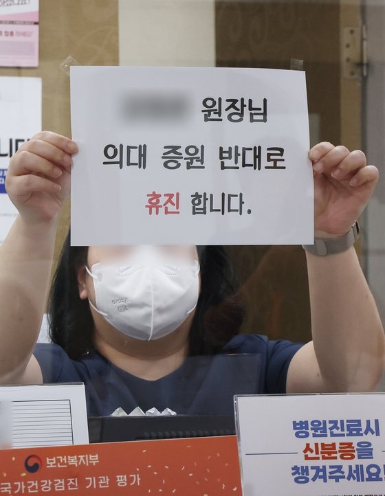 17일 오후 경기도 한 의원에서 관계자가 휴진 안내문을 붙이고 있다. 이 병원은 두 명의 의사 중 한 명만 휴진한다. 연합뉴스