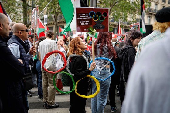 지난 5월 1일 프랑스 파리에서 한 시위자가 프랑스어로 "대량 학살자들을 위한 올림픽 반대! 이스라엘 보이콧"이라는 플래카드를 들고 있다. AFP=연합뉴스