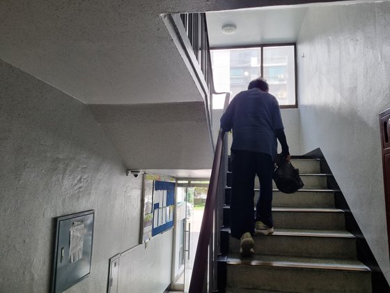 지난 17일 오후 1시 37분 승강기 운행이 중단된 인천시 중구 한 아파트단지. 한 노인이 검은색 비닐봉투를 들고 힘겹게 계단을 오르고 있다. 박종서 기자