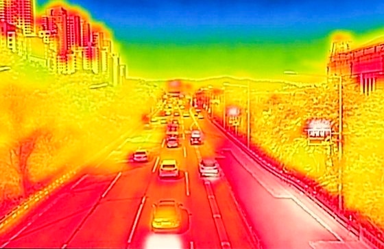 A photo of Seoul Olympic Highway captured with a thermal camera on the forecasted hot day with a temperature of 35 degrees at noon in Seoul. The picture taken with a thermal camera shows red for higher temperatures and blue for lower temperatures. Newsis