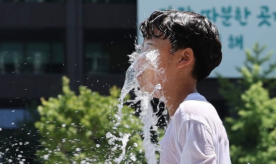 Children playing in the water fountain at Gwanghwamun Square in Seoul, cooling off in the hot weather with the daytime high temperature near 30 degrees on the 16th. News1