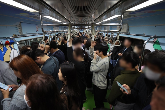 지난달 16일 오전 의자 없이 운행하는 서울 지하철 7호선 열차에 승객이 탑승해 있다. 연합뉴스
