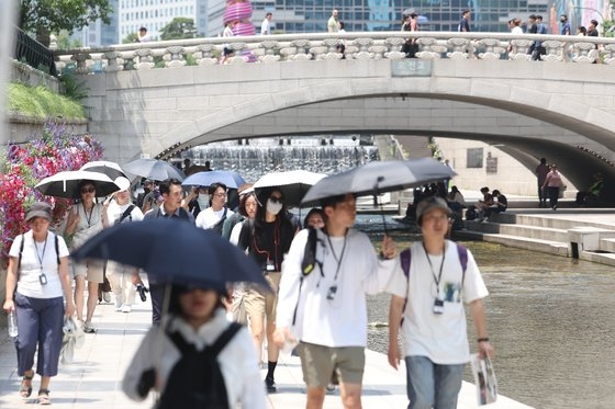 20일 서울 종로구 청계천에서 시민들이 양산을 펼쳐 따가운 햇빛을 막고 있다. 뉴스1