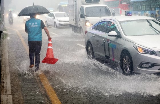 많은 양의 비가 내린 지난해 7월 13일 오후 지하철 강남역 출입구 옆 도로에 빗물이 차오르고 있다. 연합뉴스