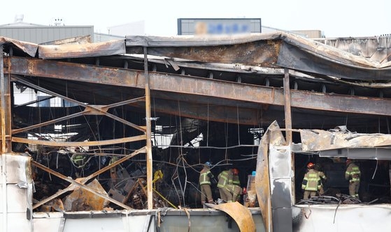소방 관계자들이 25일 오전 경기 화성시 리튬전지 제조 업체 '아리셀' 공장 화재 현장을 둘러보고 있다. 전날 이 공장에선 화재로 23명의 사망·실종자가 발생했다. 뉴스1