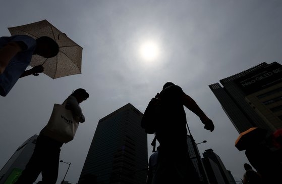 무더위가 계속되는 지난달 27일 오후 서울 광화문광장에서 시민들이 양산을 쓴 채 걸어가고 있다. 연합뉴스