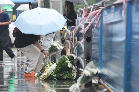 대형 교통사고가 발생한 서울 중구 시청역 7번출구 인근 사고 현장을 찾은 시민이 국화를 놓고 있다. 연합뉴스