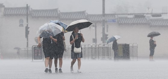 장맛비가 내리는 2일 서울 광화문광장에서 우산 쓴 학생들이 발걸음을 재촉하고 있다. 뉴스1