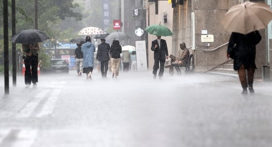 장맛비가 내리는 2일 서울 광화문광장에서 우산 쓴 시민들이 발걸음을 재촉하고 있다. 뉴스1