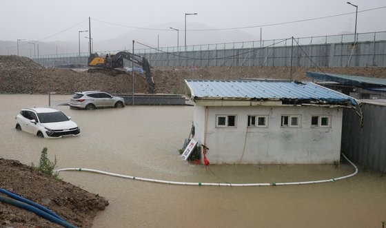 대전을 비롯해 충남지역에 많은 비가 내린 8일 오전 대전 서구 평촌동 공사현장이 침수돼 굴착기로 물을 퍼내고 있다. 뉴스1