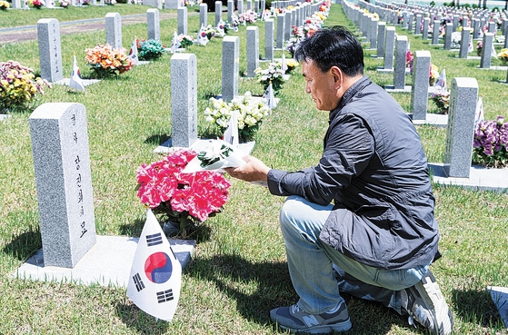 지난 5월 대전 현충원에서 김동식씨가 충남 부여 총격전으로 희생된 경찰관인 고 장진희(당시 31세) 경사 묘에 헌화하고 있다. 옆에 같이 희생된 고 나성주(당시 27세) 경사의 묘가 있다. 권혁재 사진전문기자