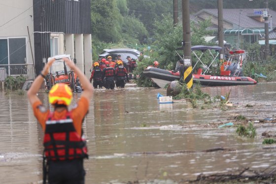 10일 새벽 강한 비가 쏟아져 대전 서구 정뱅이마을이 물에 잠긴 가운데, 소방대원들이 이날 오전 주민들을 구출하고 있다. 연합뉴스